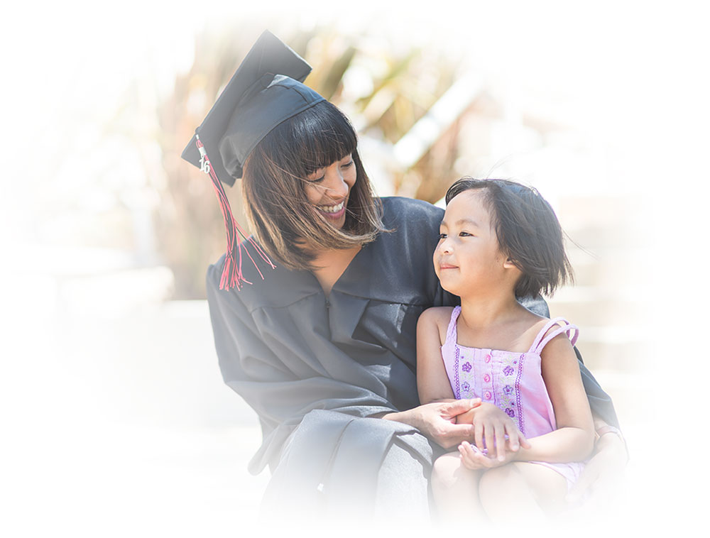 graduating mother and her young daughter sitting outside on stairs