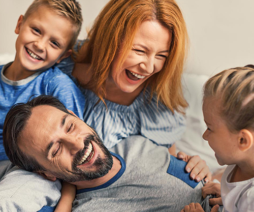Mom, dad, son and daughter laughing and smiling