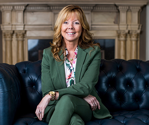 Businesswoman in a pants suit sitting on a leather sofa
