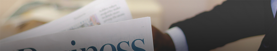 man in suit reading a newspaper