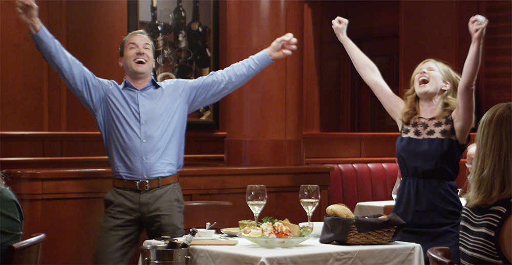 young couple standing and celebrating in a restaurant &mdash; real estate marketing video