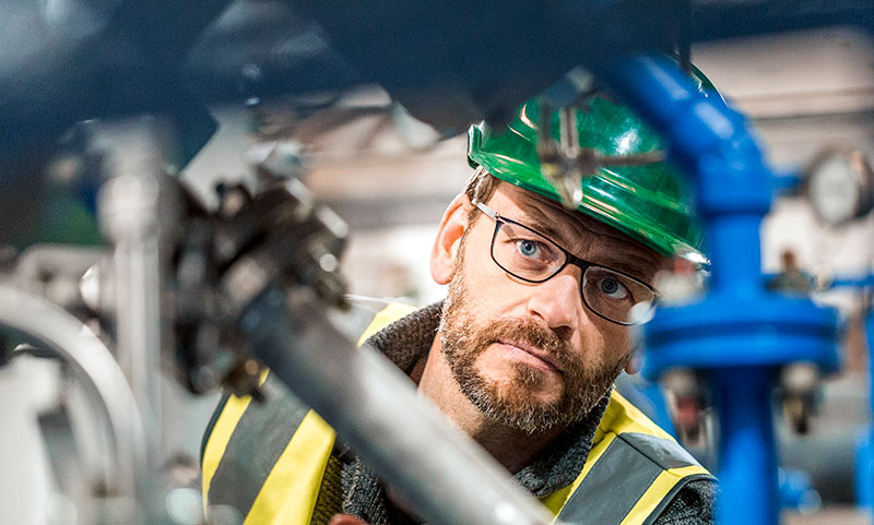 Man inspecting equipment in a manufacturing plant &mdash; insurance marketing digital work